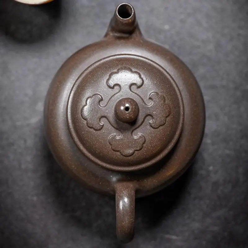 Brown ceramic Dragon Tripod Yixing Zisha teapot with ornate lid for traditional tea brewing