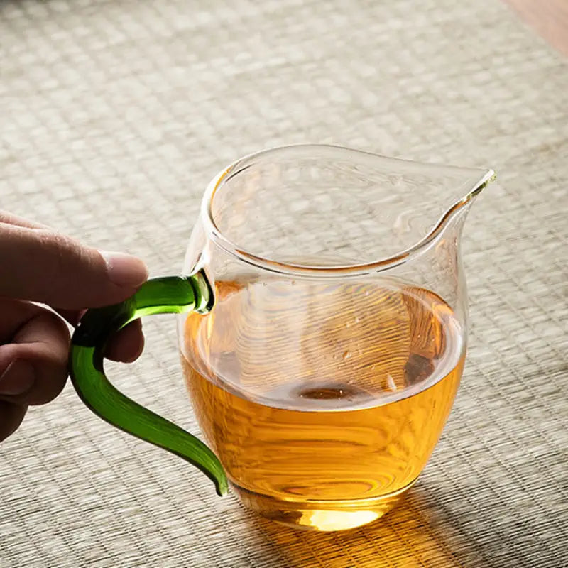 Eagle Beak tea glass pitcher with green handle made from handblown high-borosilicate glass