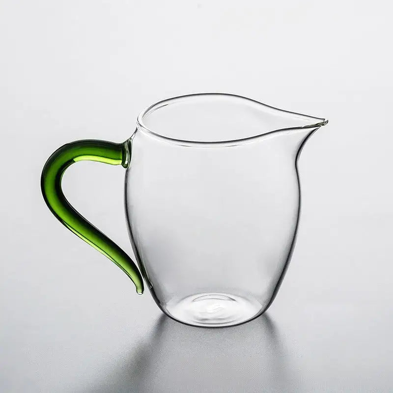 Eagle Beak tea handblown glass creamer with clear body and green handle for elegant serving