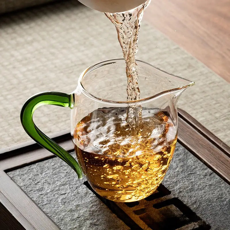 Glass pitcher with green handle for Eagle Beak Tea, handcrafted handblown high-borosilicate glass