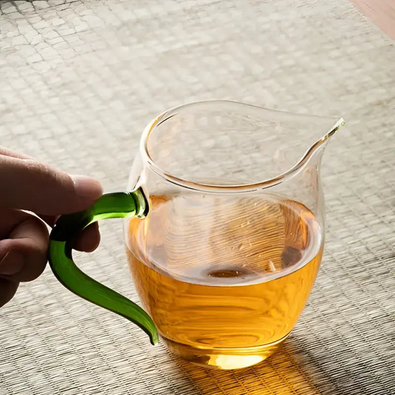 Eagle Beak tea glass pitcher with green handle made from handblown high-borosilicate glass