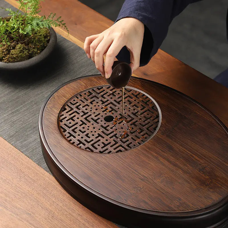 Wooden tea tray with decorative grate from Echo of Stillness Oval Bamboo Gongfu Tray