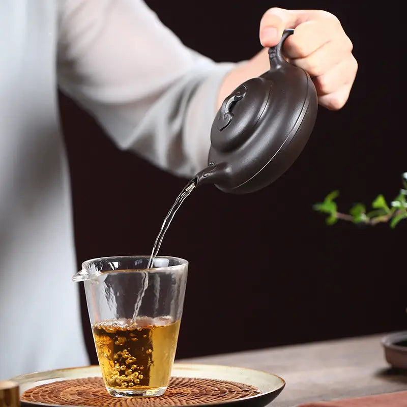 Dark Yixing Zisha teapot Eclipse pouring tea for a traditional Yixing teapot experience
