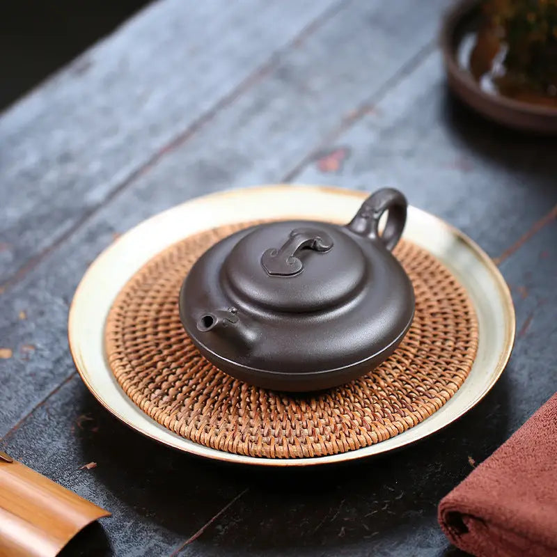 Round dark brown Yixing Zisha teapot named Eclipse for traditional tea brewing
