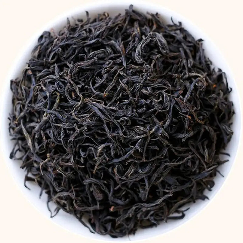 Loose leaf black tea displayed beside teapots and tea sets for Floral Sou Chong Red Tea Leave