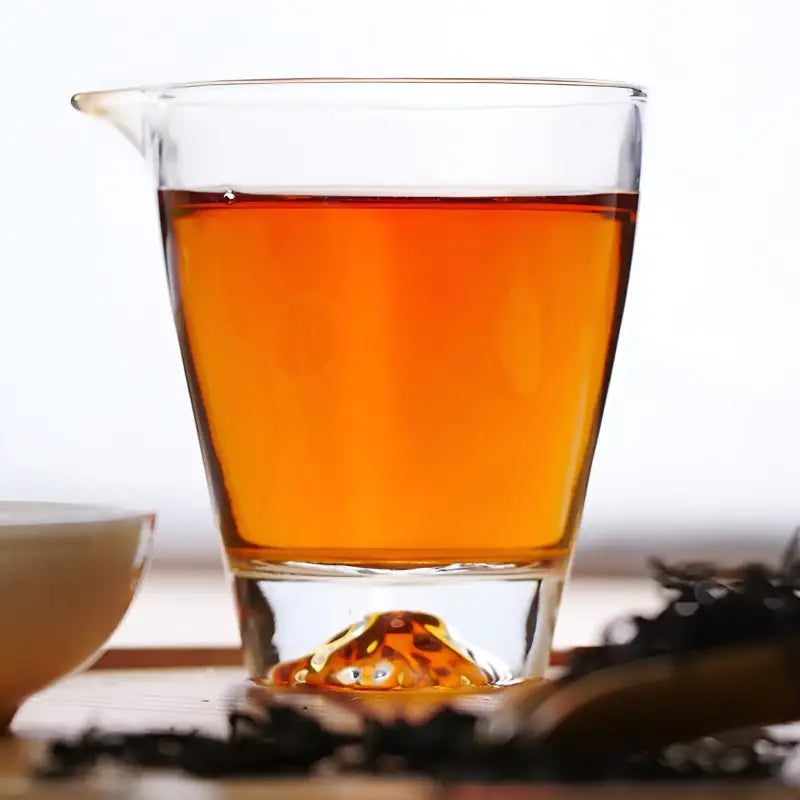 Glass pitcher of amber liquid featuring Floral Sou Chong Red Tea Leaves, perfect for teapots and tea sets