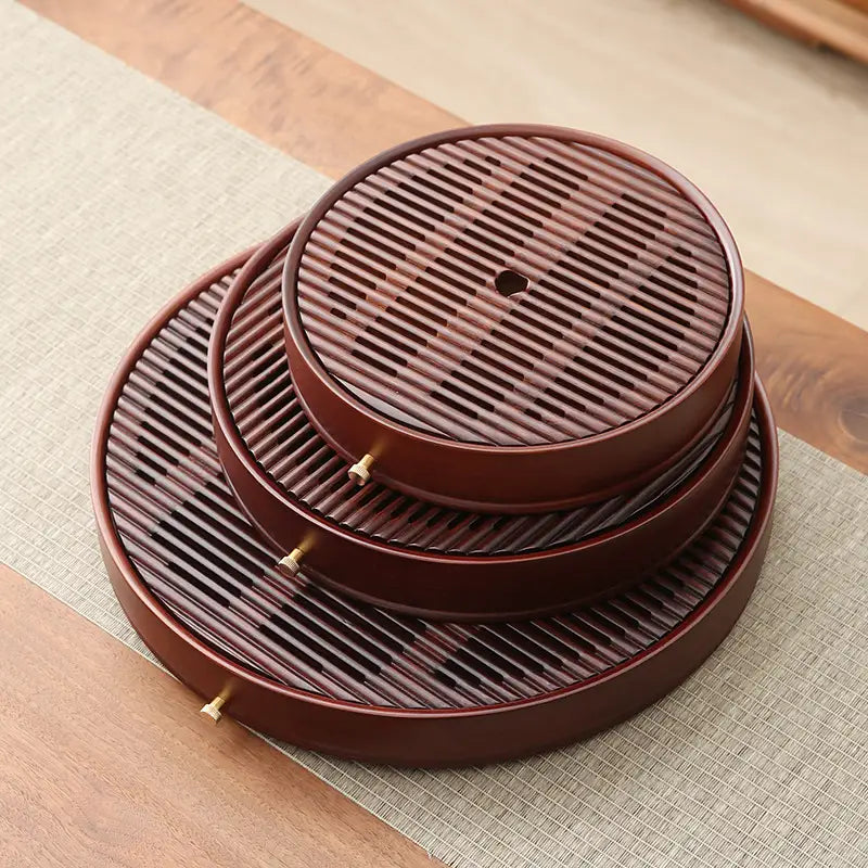 Stacked round bamboo tea tray with slotted wooden trays from Flow Circle