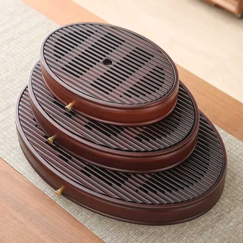 Stacked oval wooden tea trays from Flowing Zen bamboo tea tray collection