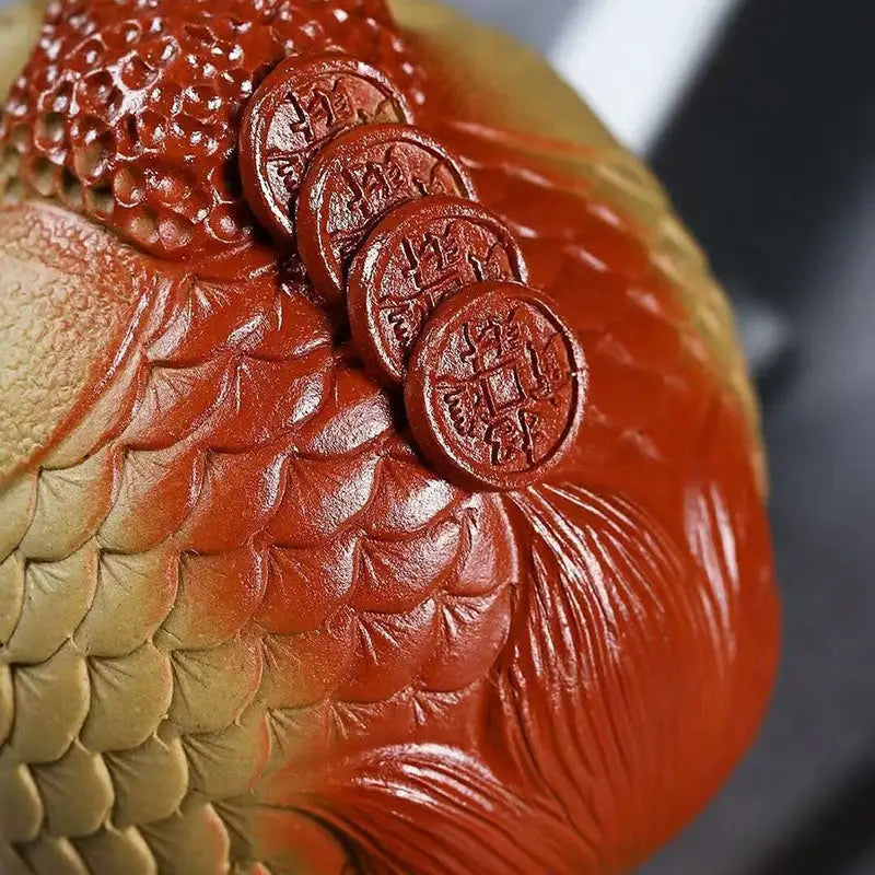 Red and gold textured sculpture with coins, a feng shui tea pet for prosperity