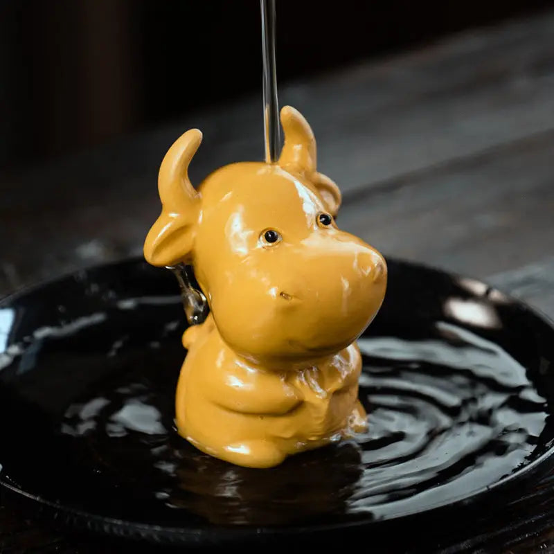 Yellow ceramic cow figurine Fortune Grazer tea pet guide for feng shui tips