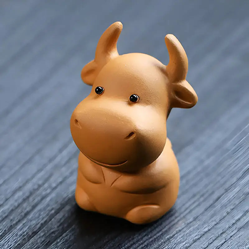 Cute brown ceramic Fortune Grazer cow figurine, ideal as a tea pet and for feng shui tips