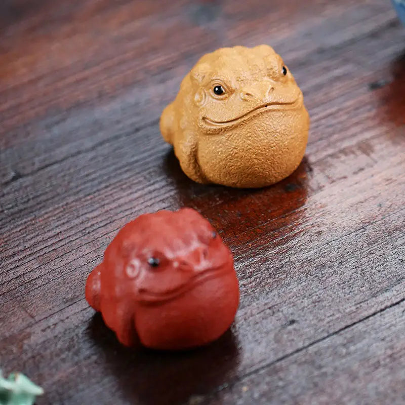 Two small frog figurines from Fortune Warden Toad Yixing Zisha Tea Pet Guide