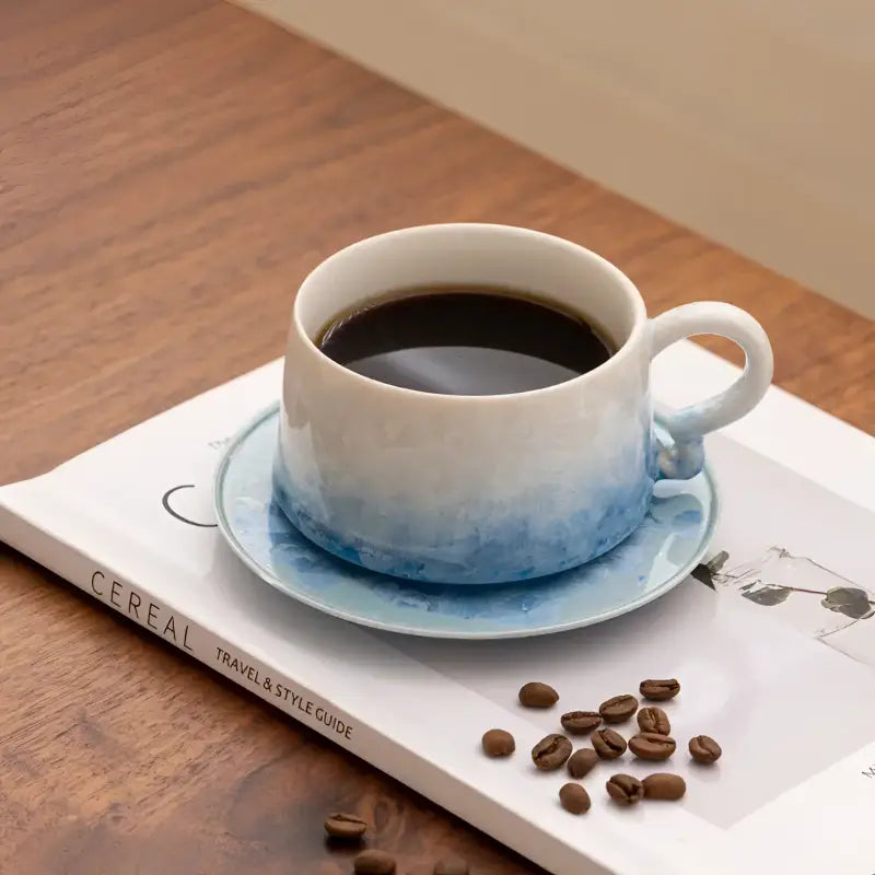 Blue and white ceramic coffee cup with tenmoku glaze on matching saucer