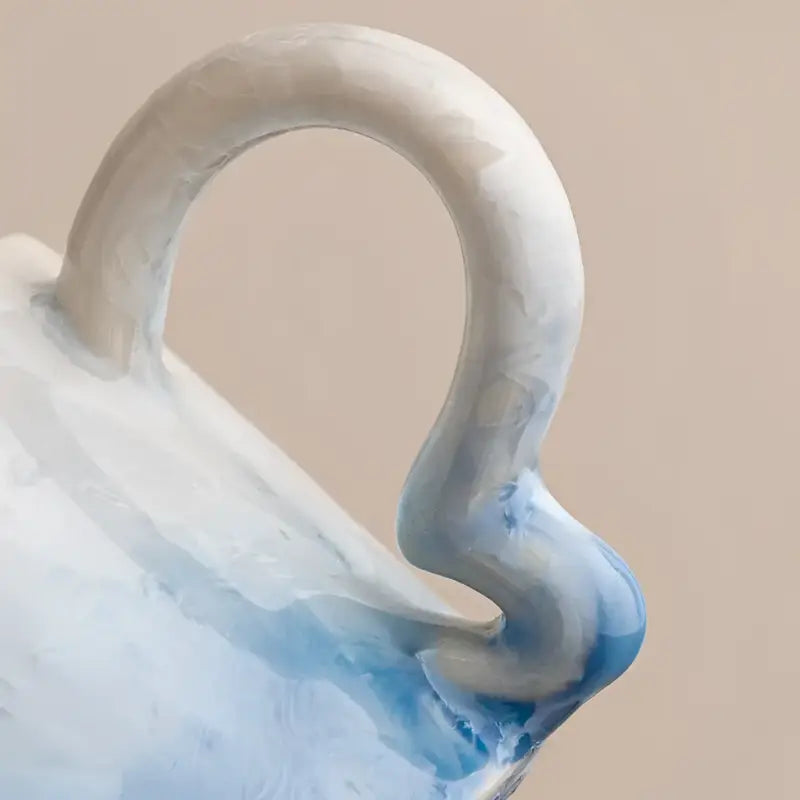 Blue and white ceramic coffee cup handle with tenmoku glaze on matching saucer