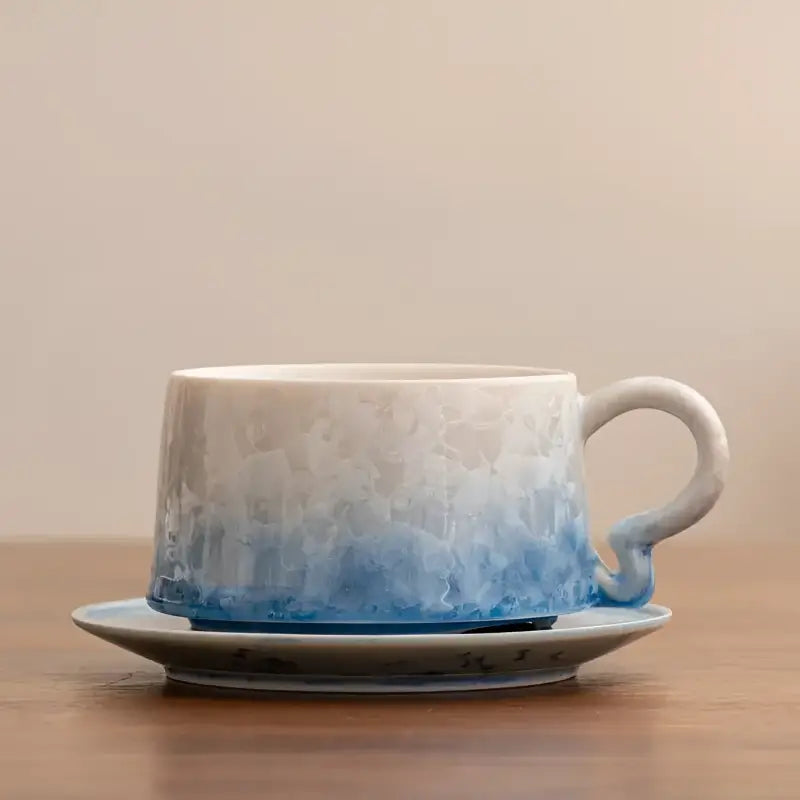 Blue and white crystalline glazed ceramic coffee cup with tenmoku glaze and matching saucer
