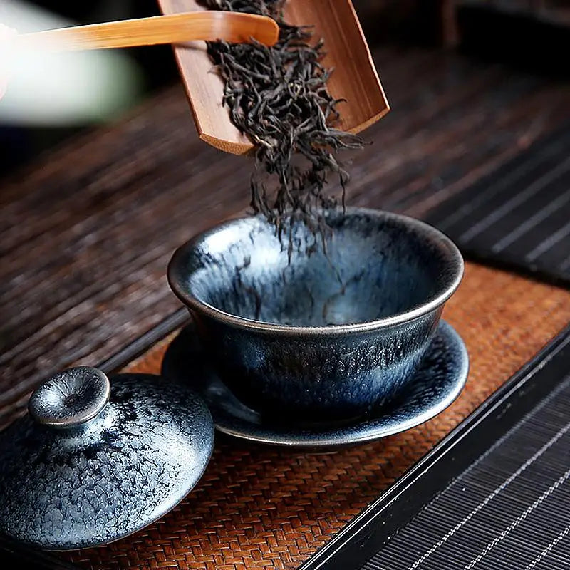 Blue-glazed Glacier Tea Set with crystalline and tenmoku glaze and loose tea leaves