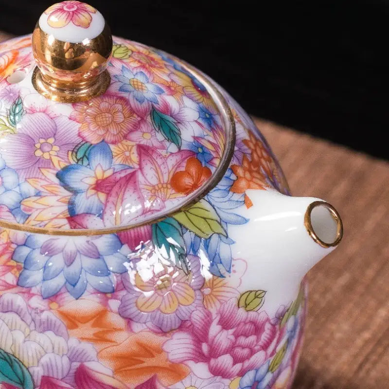 Floral-patterned porcelain teapot with gold floral enamel design, showcasing Jingdezhen enamel art