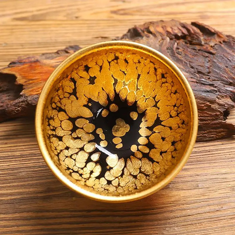 Gold-speckled black jian zhan teacup with radiant golden accents for gongfu tea enjoyment