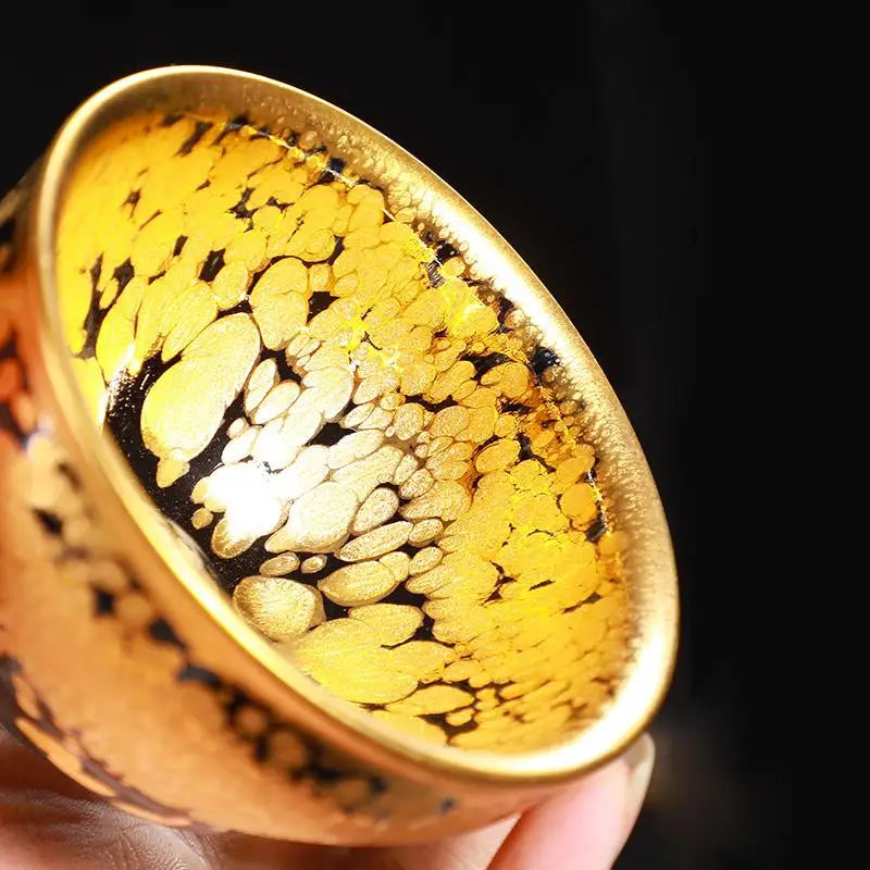Radiant golden jian zhan teacup with mottled design for gongfu tea brewing