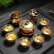 Black and gold tea set featuring a fairness pitcher from the Gold Jian Zhan Tea collection