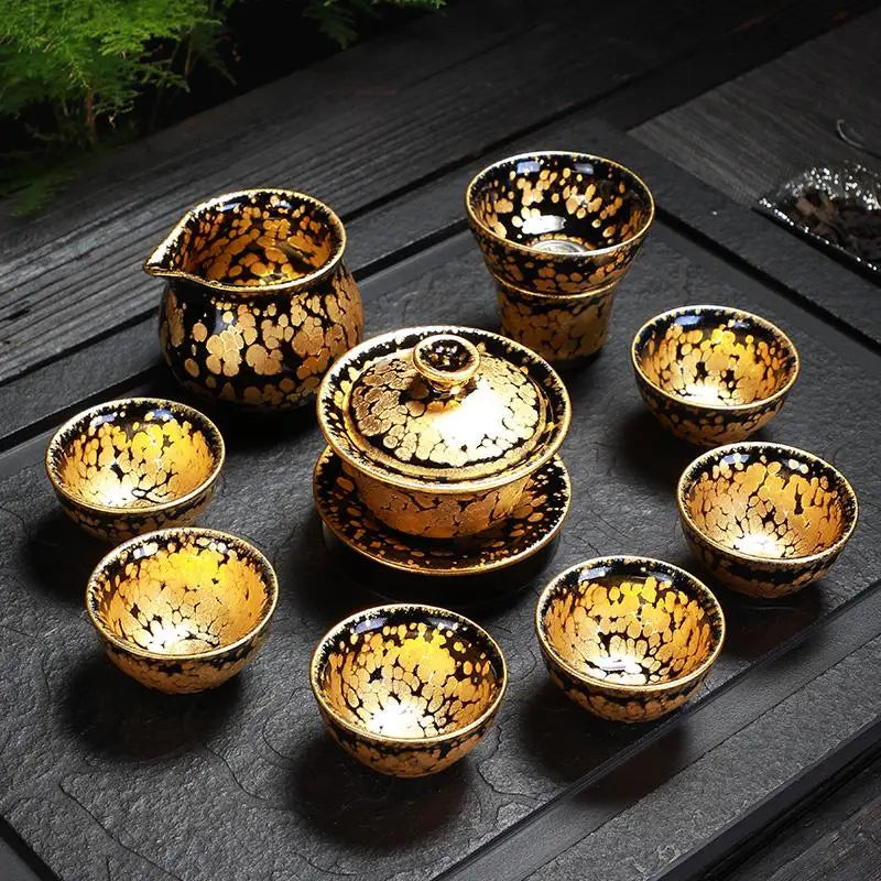 Black and gold tea set featuring a fairness pitcher from the Gold Jian Zhan Tea collection