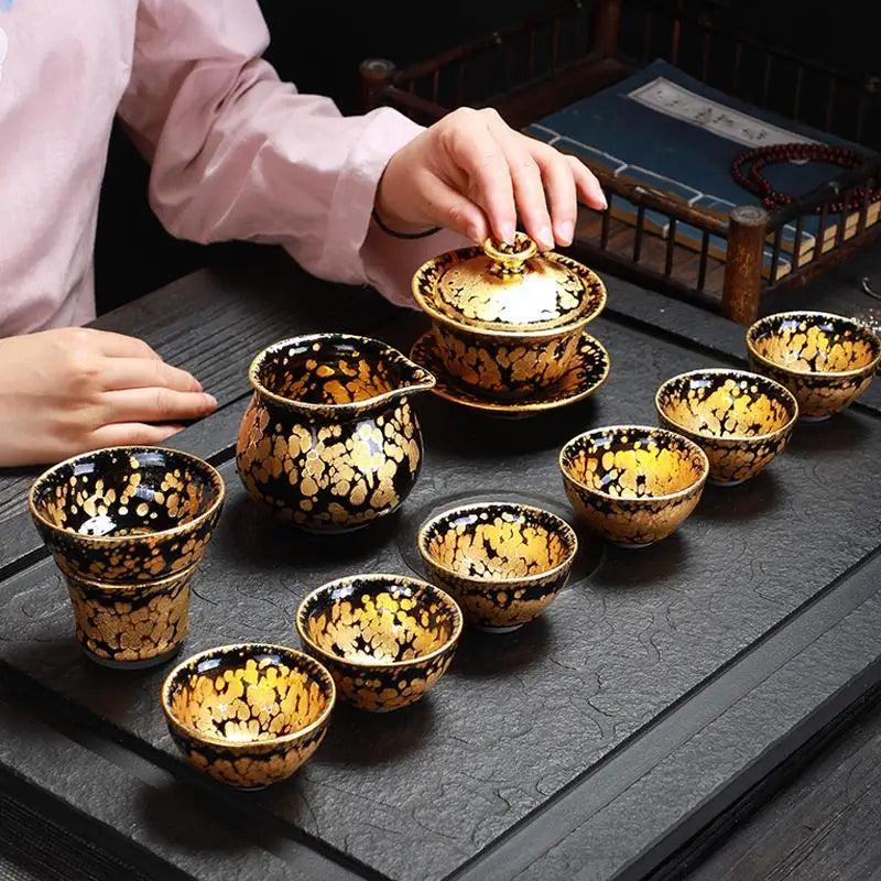 Black and gold tea set featuring Gold Jian Zhan and fairness pitcher for elegant tea brewing