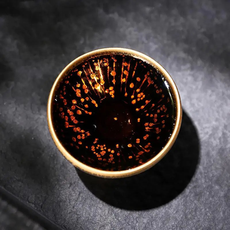 Dark liquid in ceramic bowl with metallic flecks for Golden Drops Jian Zhan Tea connoisseurs