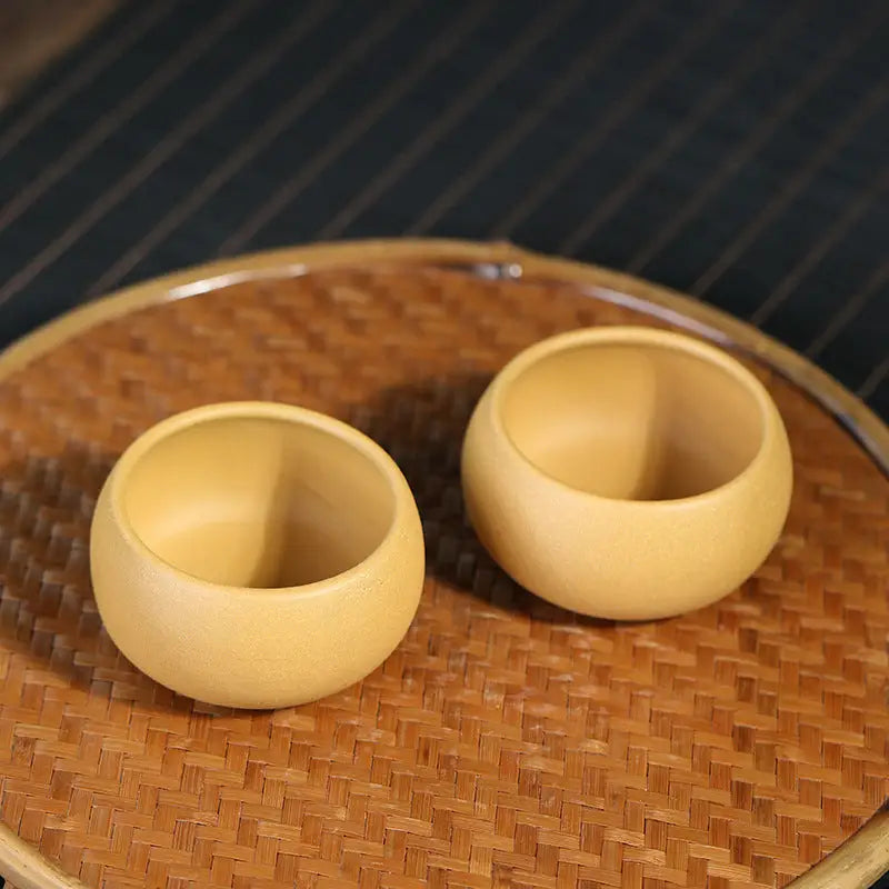 Two round wooden cups from Golden Ember Teacup in a Yixing Zisha Gongfu Tea Set