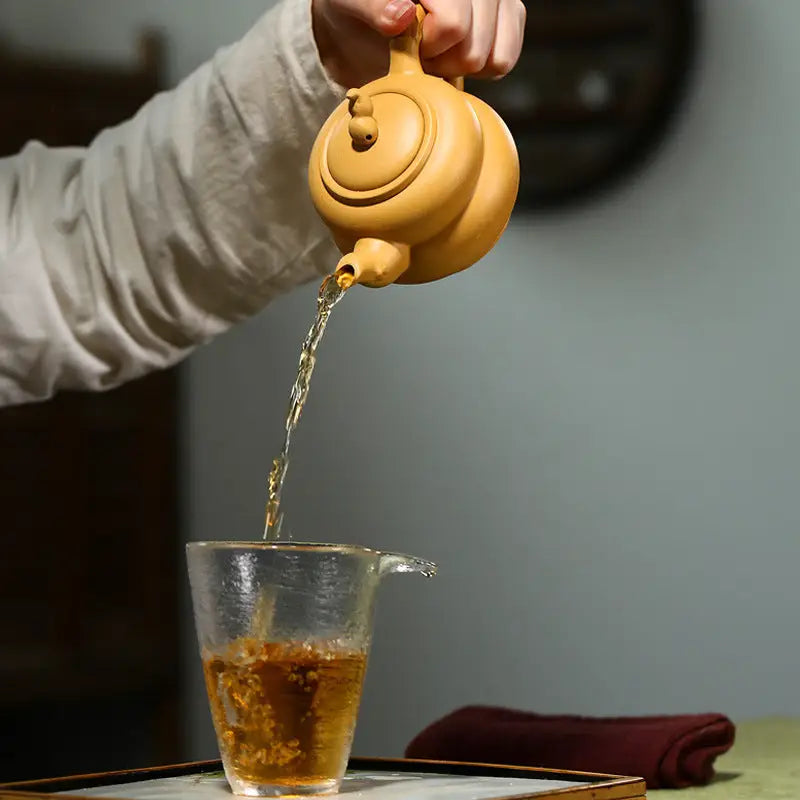 Earthenware teapot pouring tea made of Yixing Zisha Duanni clay for Gongfu tea brewing