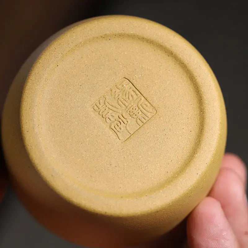 Ceramic cup base with stamped mark for Golden Harmony crafted from yellow Duanni clay