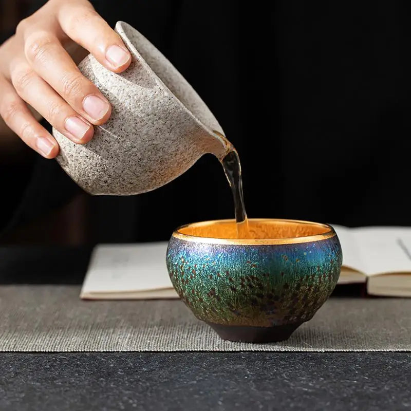 Tea being poured into a colorful cup with Golden Magic Jian Zhan Tea, showcasing magic jian zhan
