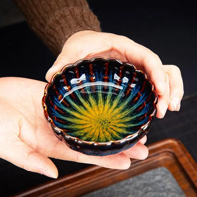 Hand-held colorful ceramic Golden Peacock Jian Zhan Tea Cup showcasing Zhan Tea craftsmanship