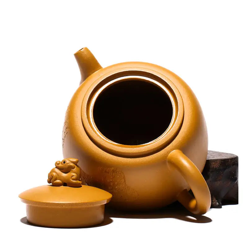 Earthenware Yixing teapot with guardian beast lid in golden Duanni clay