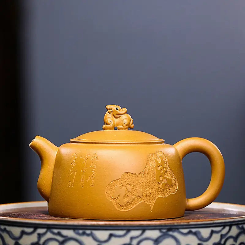 Ornate yellow-brown Yixing teapot with guardian beast lid in golden Duanni clay