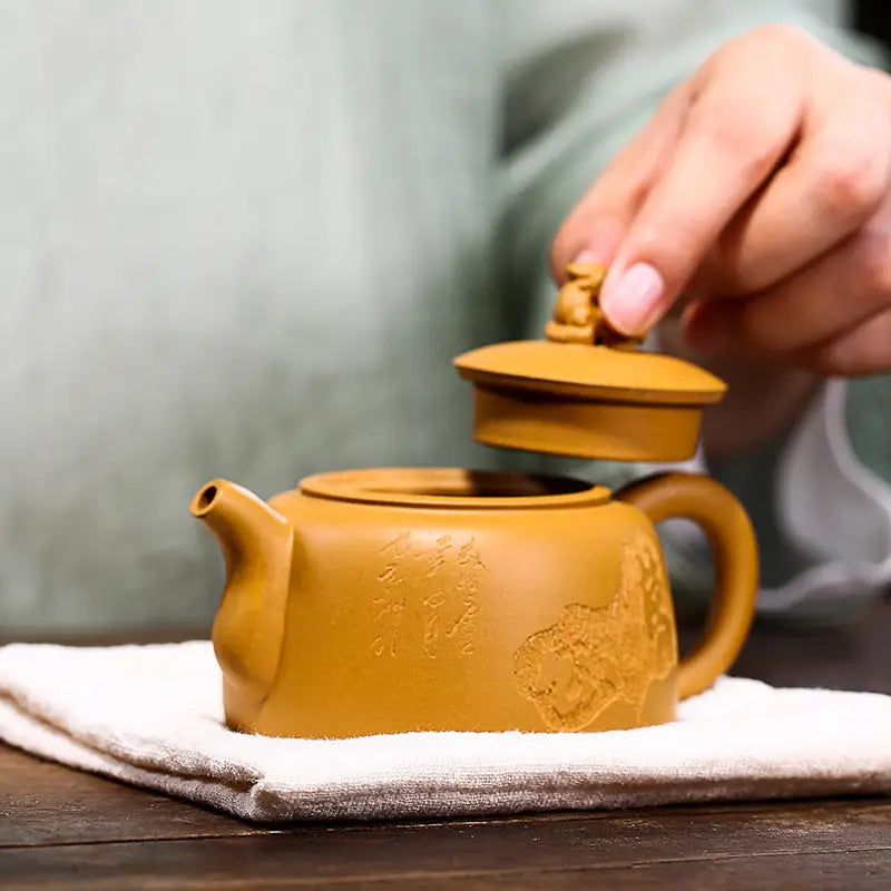Earthenware Yixing teapot with guardian beast lid in golden Duanni clay