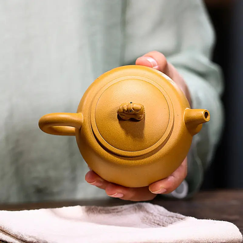 Round brown Yixing teapot with guardian beast lid made from golden Duanni clay