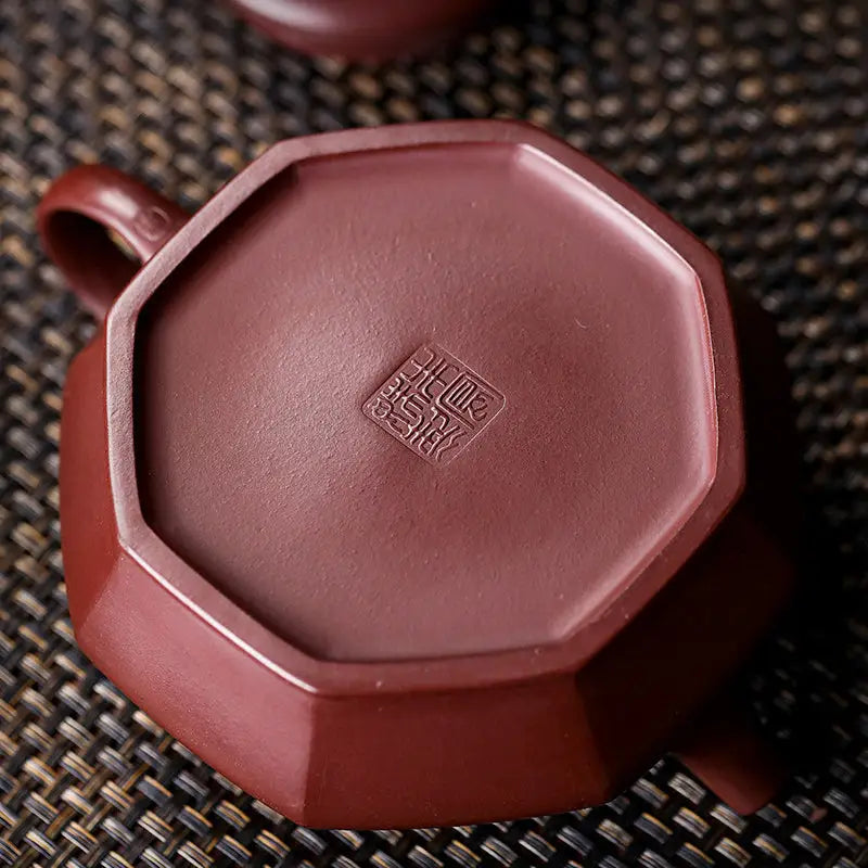 Octagonal purple clay teapot base showcasing HexaSeal Yixing with Chinese seal script
