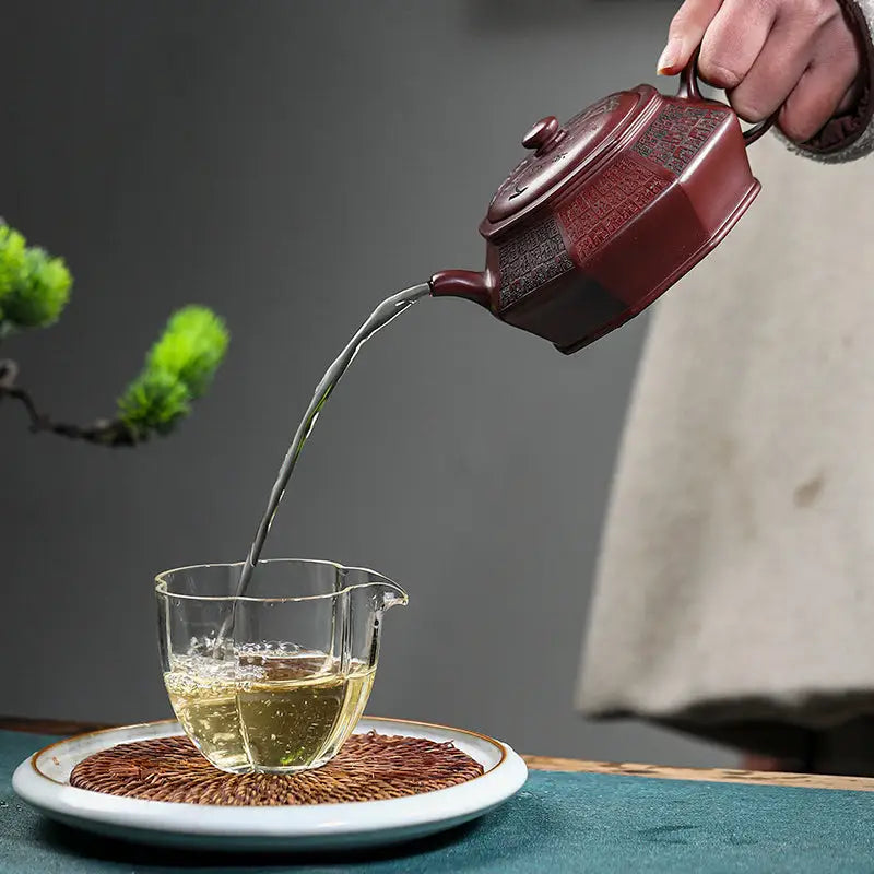 Octagonal red-brown yixing zisha teapot pouring tea showcasing HexaSeal Yixing Chinese seal script