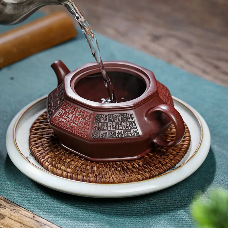 Octagonal brown Yixing Zisha teapot being filled, showcasing HexaSeal Yixing Chinese seal script