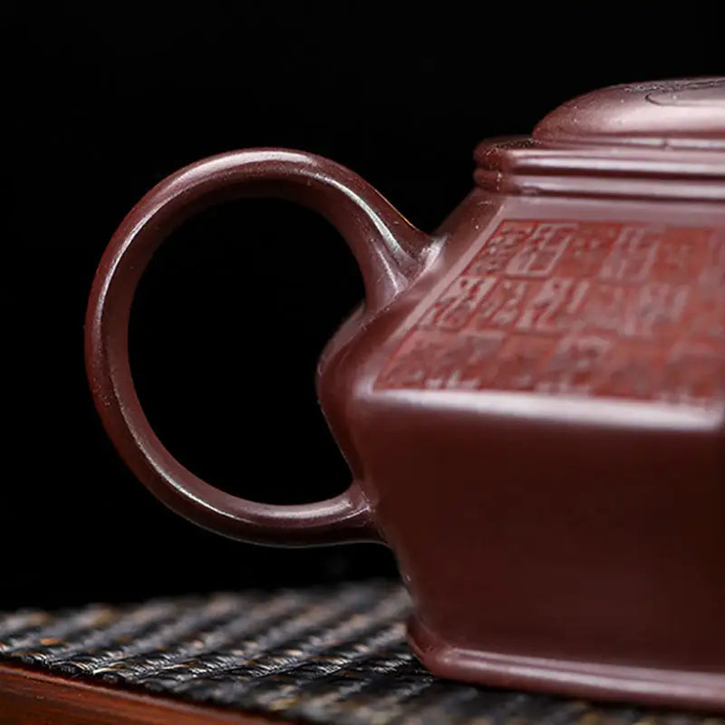 Maroon ceramic teapot with circular handle from HexaSeal Yixing featuring Chinese seal script