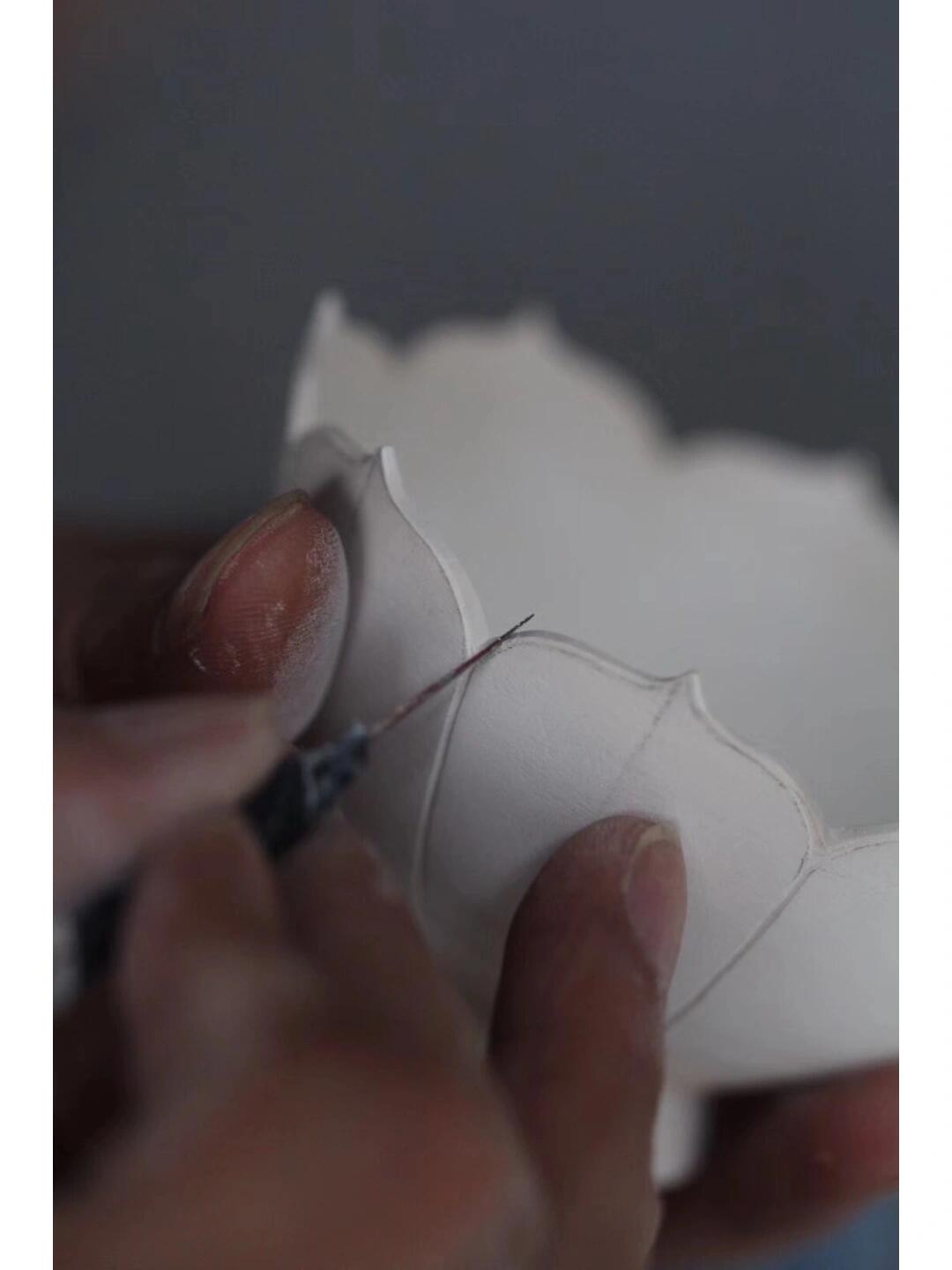 White ceramic bowl being carved from Dehua porcelain, a renowned Chinese ceramic from Fujian Province