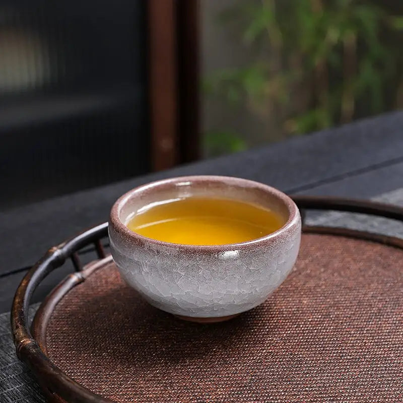 Ceramic Ivory Rift crackled grape teacup with rift crackled glaze filled with tea