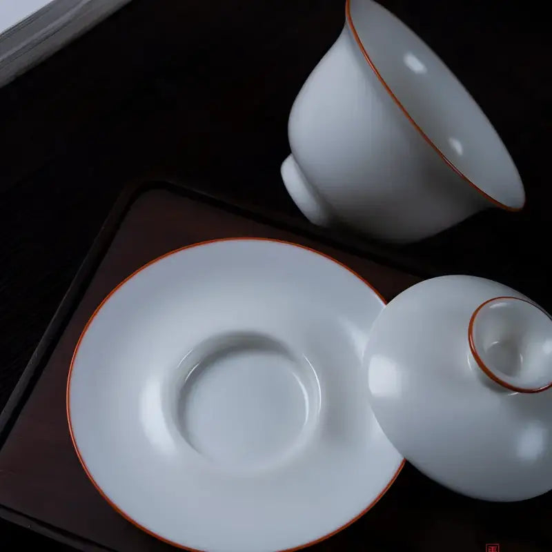 White porcelain tea set with red trim from Ivory White Ru Kiln, featuring Dehua porcelain and crackled Ru kiln finish