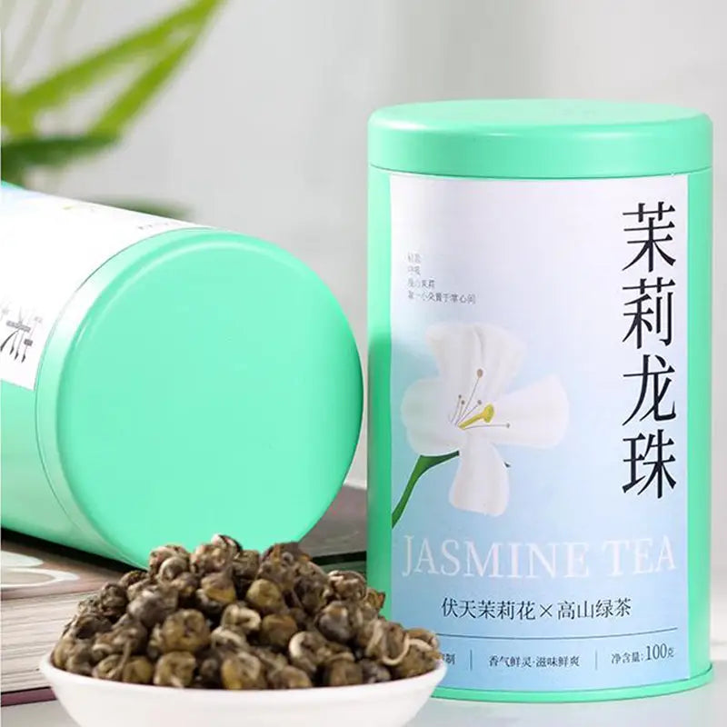 Jasmine Dragon Ball Tea Leaves in a light green tin with teapots and tea sets display