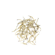 Pile of dried pale green jasmine silver needle white tea leaves with fresh jasmine flowers