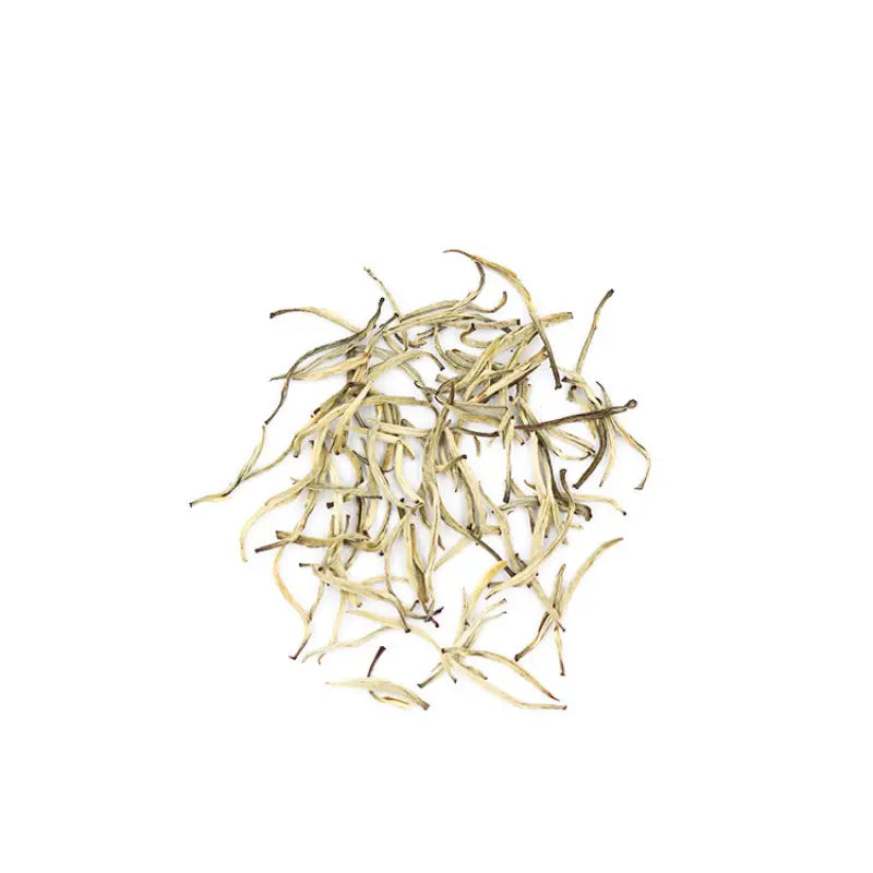 Pile of dried pale green jasmine silver needle white tea leaves with fresh jasmine flowers