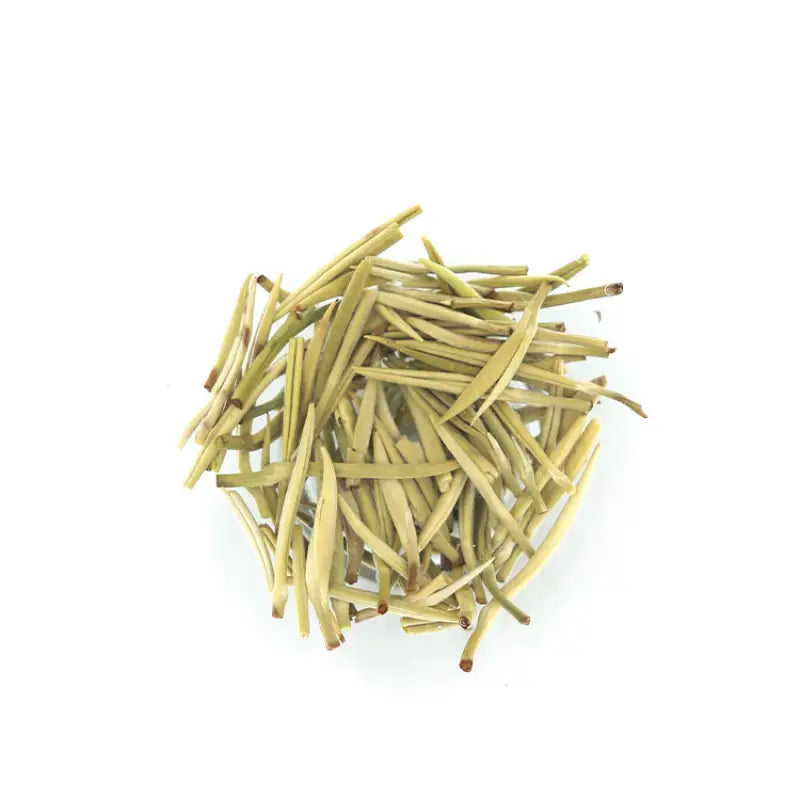 Pile of dried pale green jasmine silver needle white tea leaves with fresh jasmine flowers