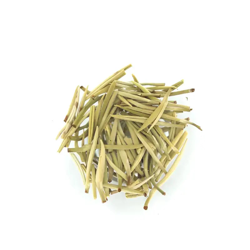 Pile of dried pale green jasmine silver needle white tea leaves with fresh jasmine flowers