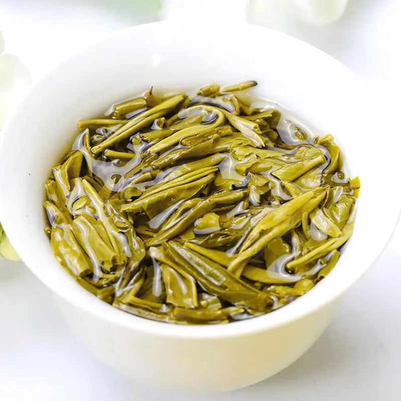 Green tea leaves in a white bowl for Jasmine Tea Leave, perfect with teapots and tea sets