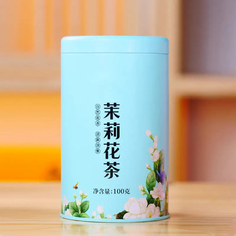Light blue tea tin for Jasmine Tea Leaves displayed with teapots and tea sets